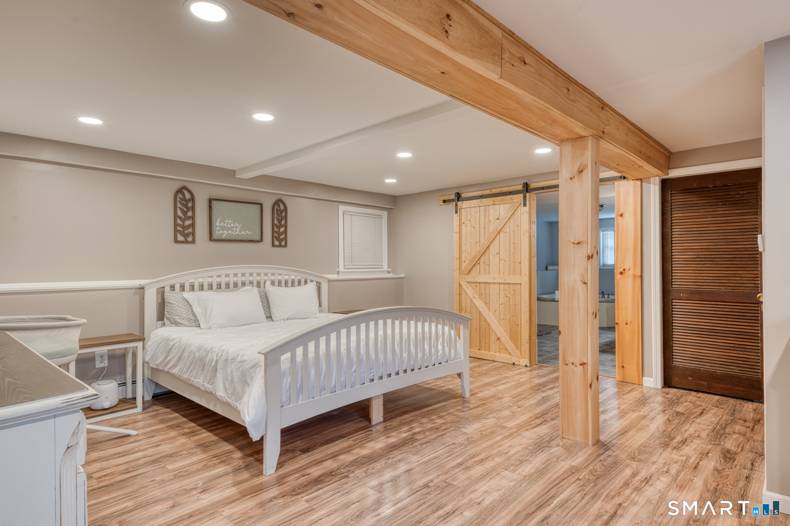 23 Thompson Hill Road Columbia, CT 06237 - Photo 26 of 39 Lower-level family room with barn doors to full bath and door to walk out basement with workshop area