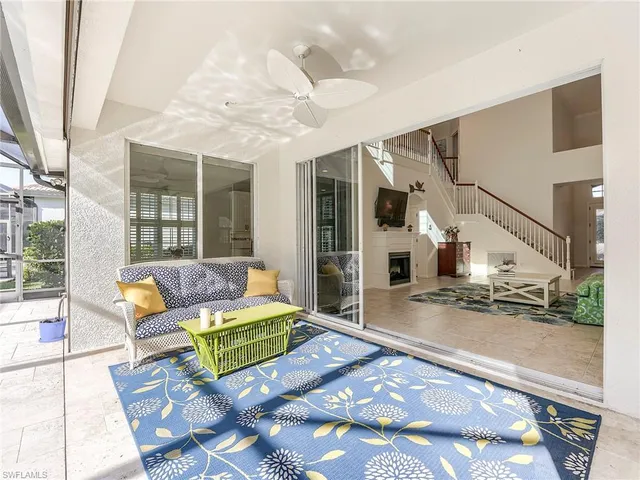 a living room with patio furniture and a floor to ceiling window