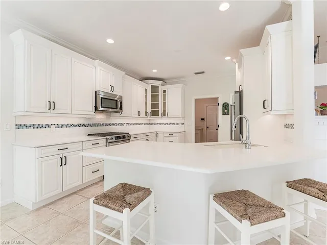 a kitchen with white cabinets and appliances