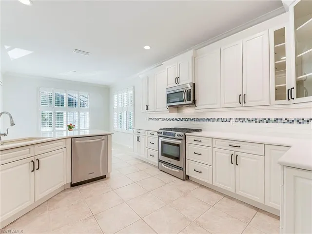 a kitchen with granite countertop white cabinets and white appliances