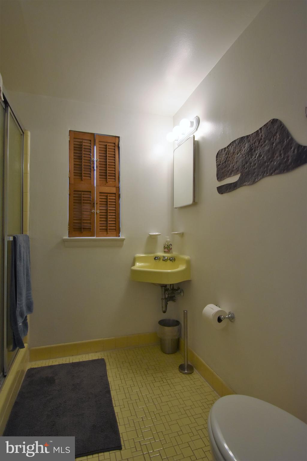 6405 Middleburg Lane Bethesda, MD 20817 - Photo 11 of 21 a bathroom with a sink a toilet a mirror and vanity