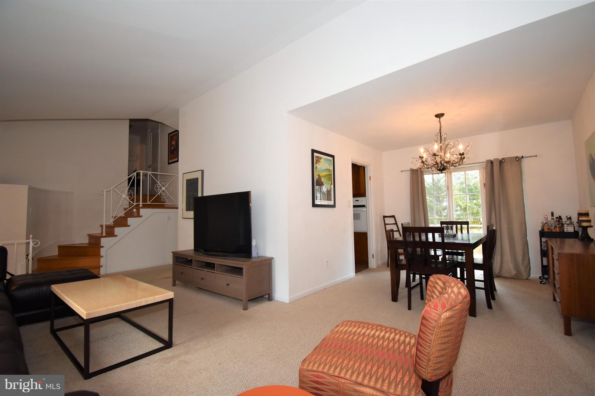 6405 Middleburg Lane Bethesda, MD 20817 - Photo 4 of 21 a living room with furniture a chandelier and a flat screen tv
