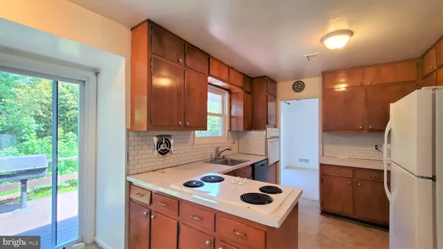 a kitchen with a sink a refrigerator and window