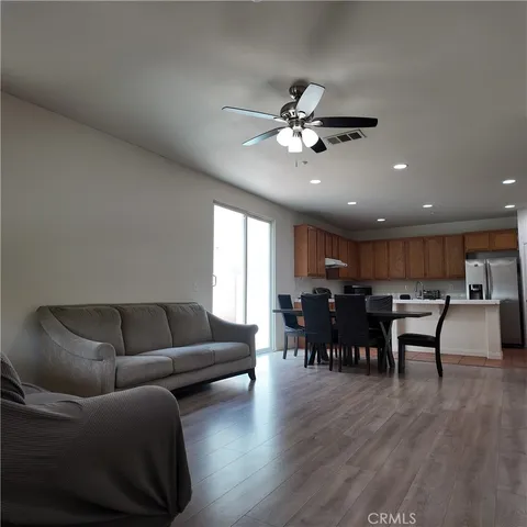 a living room with furniture a wooden floor and a dining table