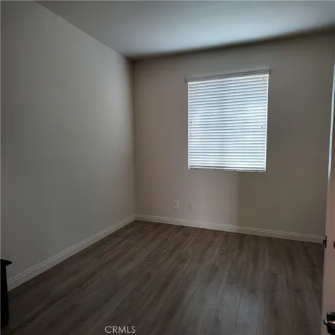 an empty room with wooden floor and a window