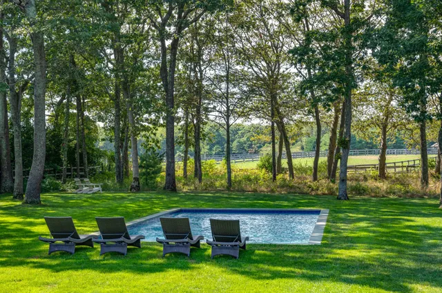 a view of backyard with swimming pool and outdoor seating