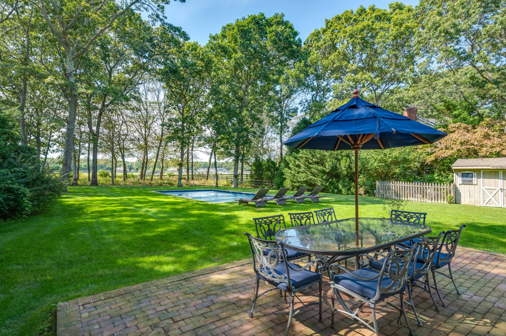 Undisclosed Address Water Mill, NY 11976 - Photo 18 of 28 a view of a table and chairs under an umbrella