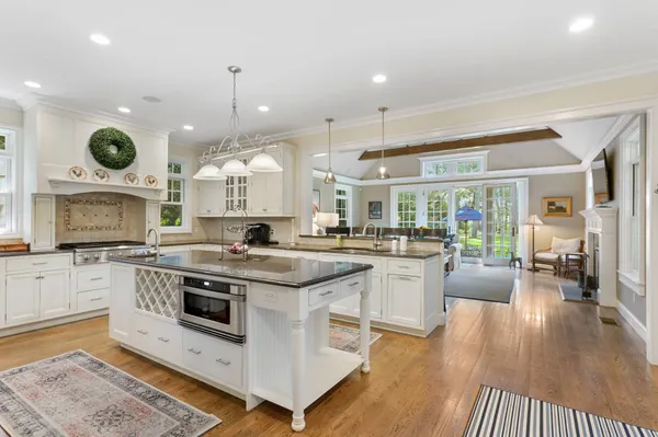 a kitchen with a stove oven and a view of living room