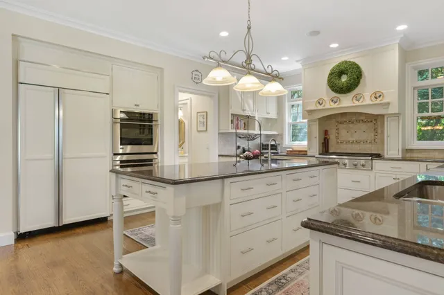 a large kitchen with granite countertop a sink a stove and cabinets