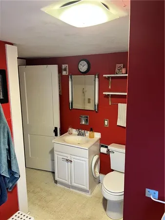 a bathroom with a toilet sink and mirror
