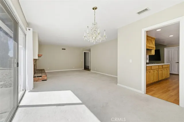 a view of a livingroom with a furniture wooden floor and kitchen view