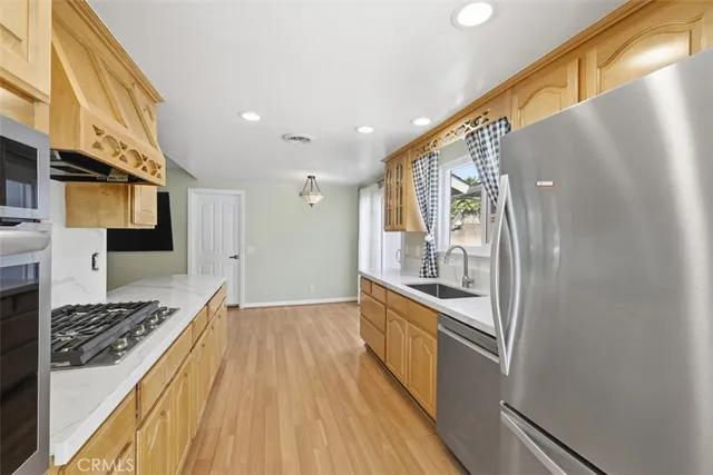 a kitchen with stainless steel appliances granite countertop a refrigerator and a stove top oven