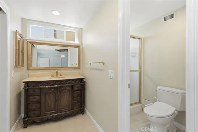 a bathroom with a granite countertop toilet sink and mirror