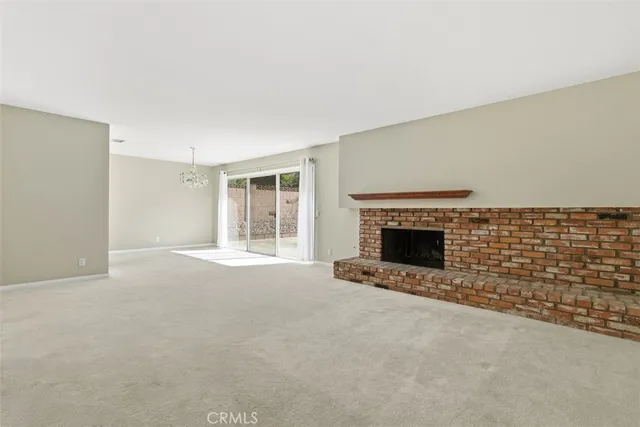 a view of an empty room with a fireplace and a window