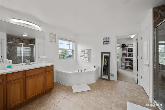 a spacious bathroom with a double vanity sink mirror and bathtub