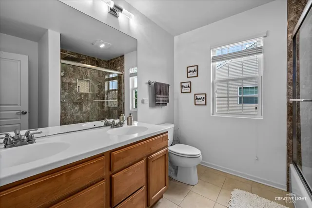 a spacious bathroom with a granite countertop sink a toilet a mirror and a shower