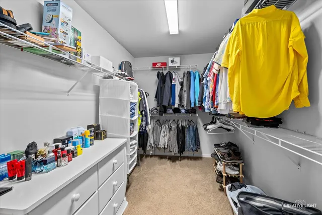 a view of walk in closet with clothes and shoes