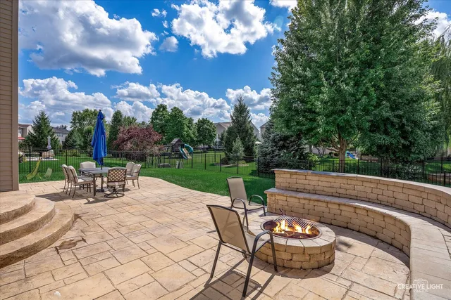 a view of a patio with a dining table and chairs with a fire pit