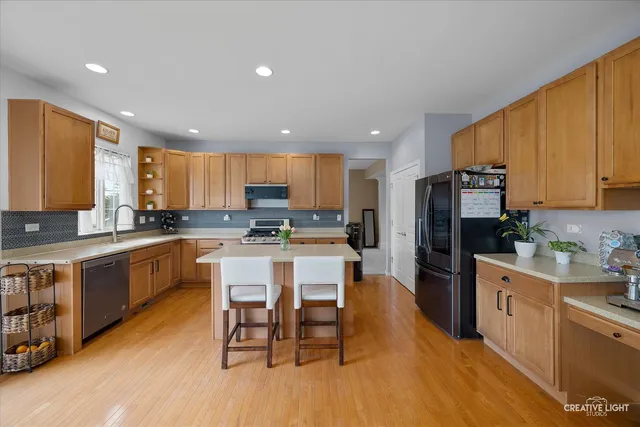 a kitchen with a sink a counter top space stainless steel appliances and cabinets