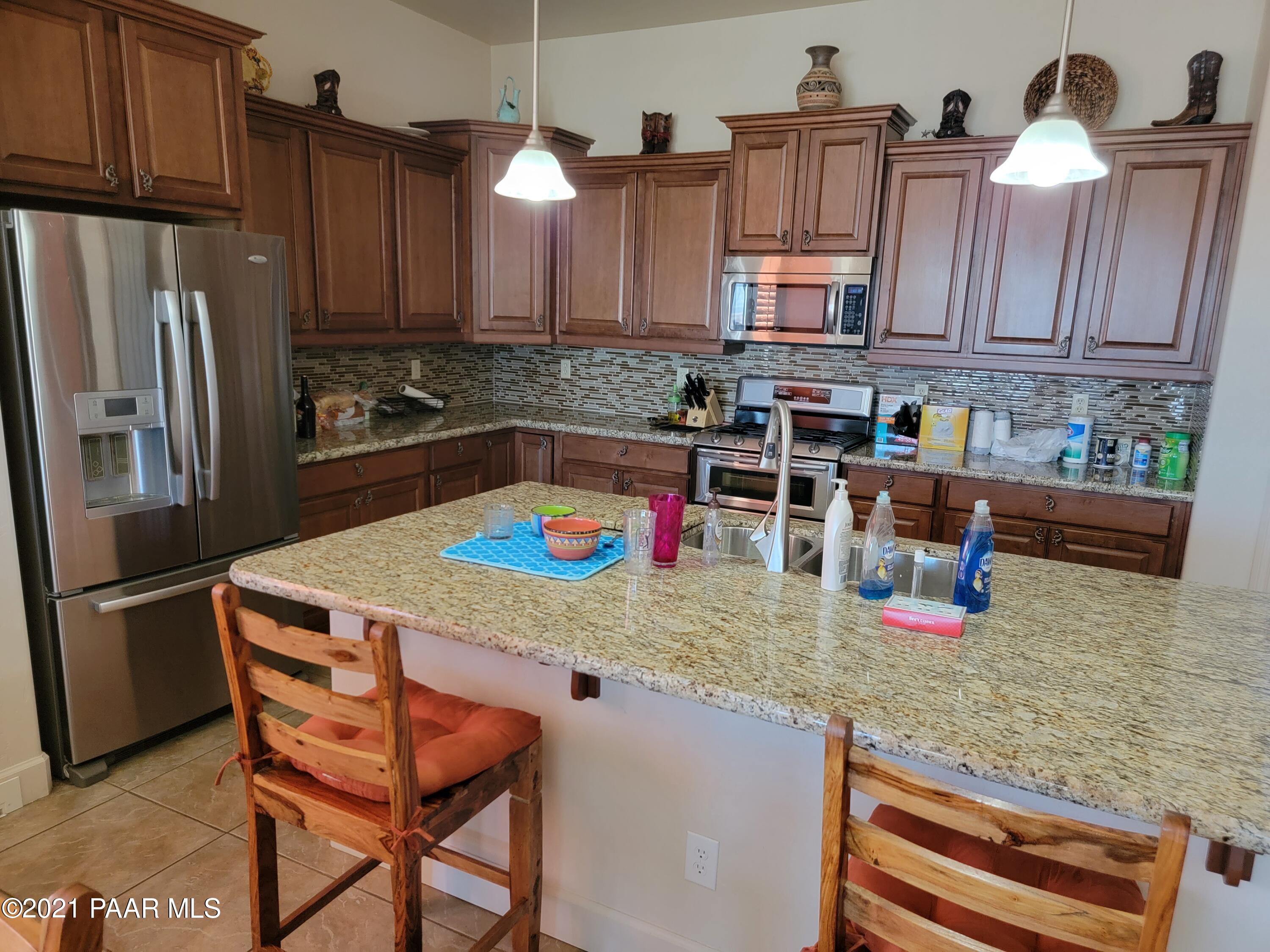 1181 Stack Rock Road Prescott Valley, AZ 86314 - Photo 6 of 25 a kitchen with stainless steel appliances granite countertop a refrigerator a sink and wooden cabinets