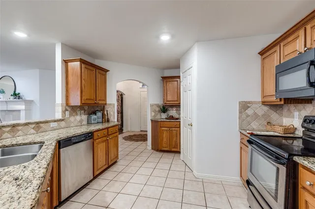 a kitchen with a sink a stove top oven and refrigerator