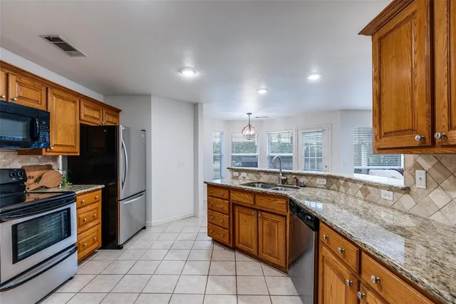 a kitchen with stainless steel appliances granite countertop a sink and cabinets