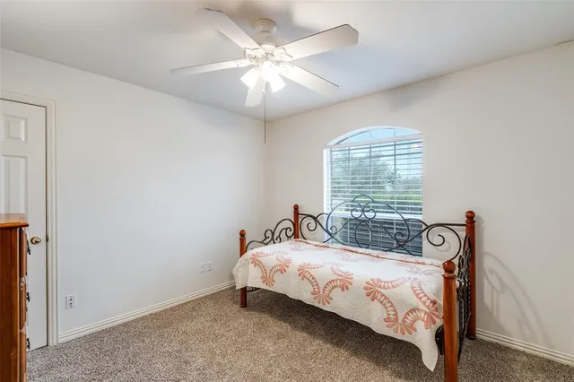 a bed sitting in a bedroom next to a window