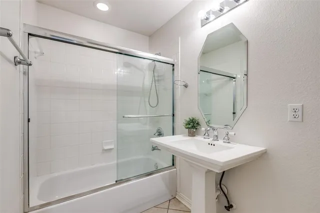 a bathroom with a sink mirror and a bathtub