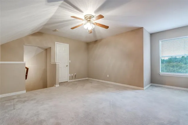 an empty room with fan and windows