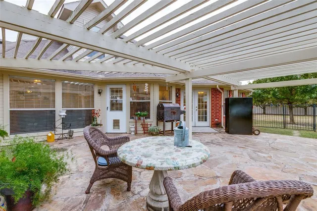 a view of a patio with table and chairs and potted plants