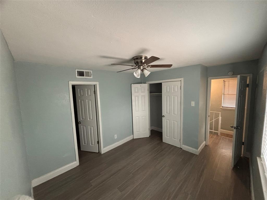 301 Rolston Road, Unit 315101 Irving, TX 75060 - Photo 8 of 12 Spacious room featuring wood-finish flooring, light blue wall paint, white trim, and a ceiling fan with light fixture