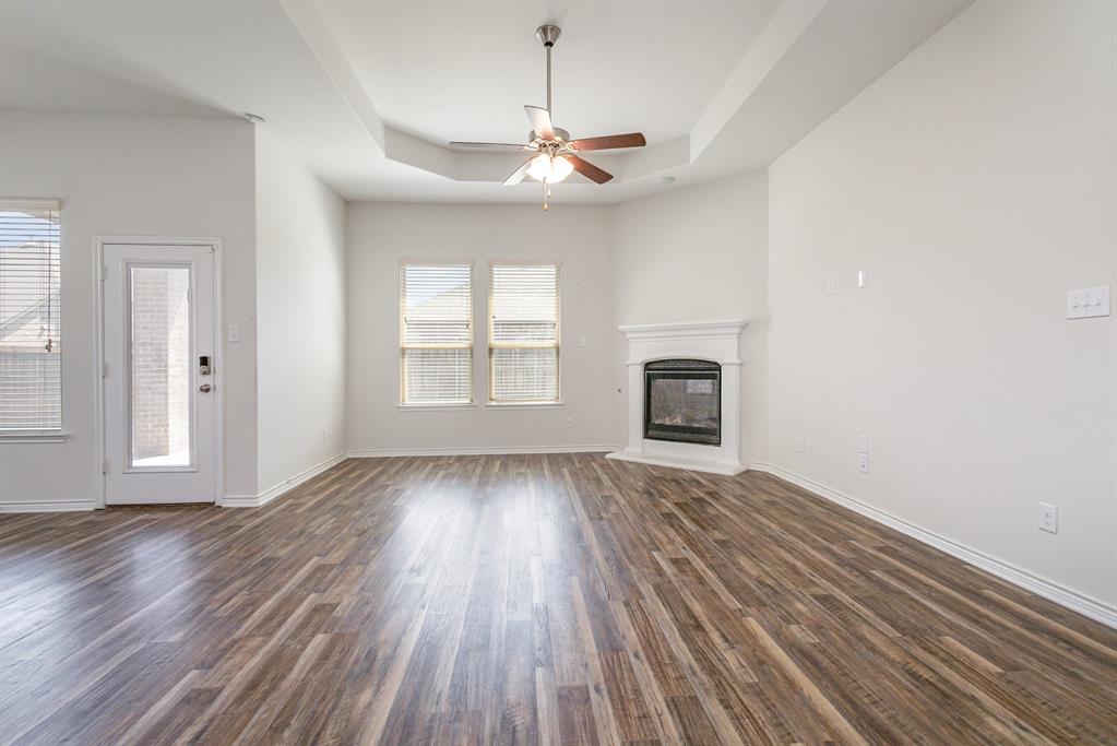 516 Maverick Street Anna, TX 75409 - Photo 11 of 28 a view of an empty room with wooden floor fireplace and a window