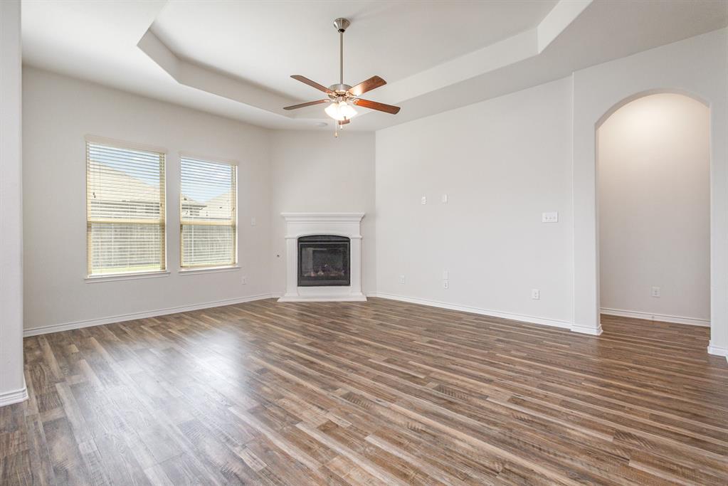 516 Maverick Street Anna, TX 75409 - Photo 12 of 28 an empty room with wooden floor chandelier fan and windows