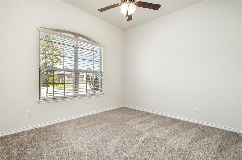 516 Maverick Street Anna, TX 75409 - Photo 16 of 28 an empty room with a chandelier fan and windows