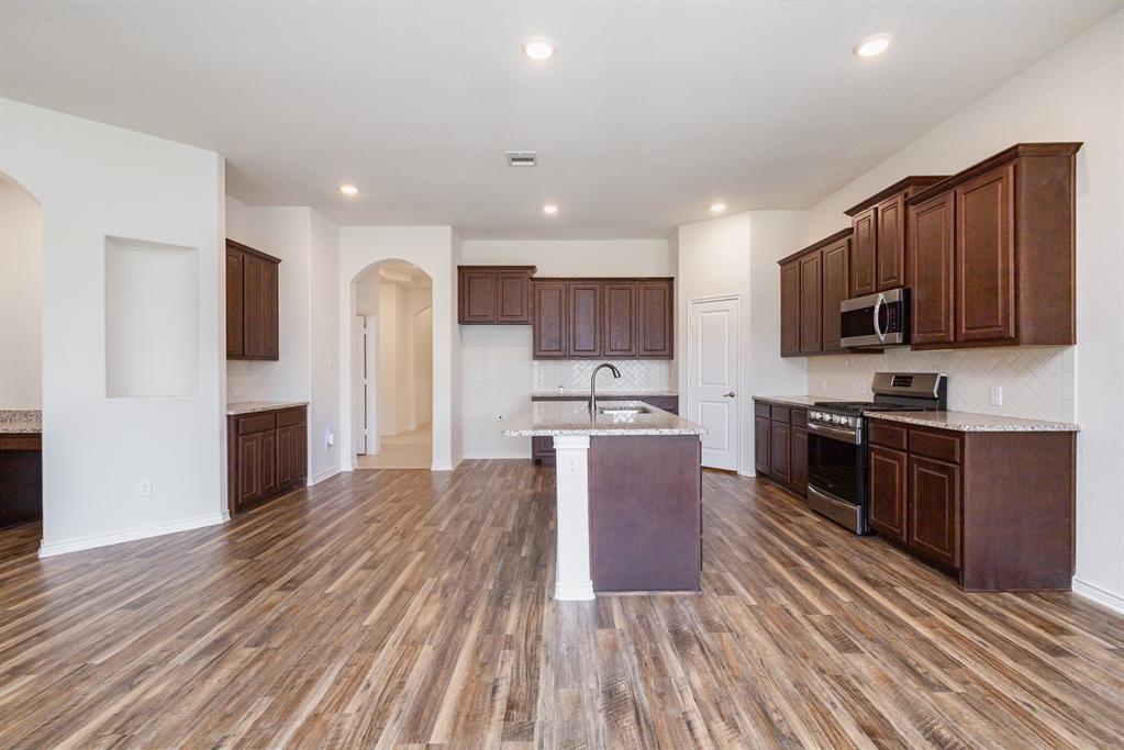 516 Maverick Street Anna, TX 75409 - Photo 5 of 28 a kitchen with stainless steel appliances granite countertop a refrigerator stove top oven and sink