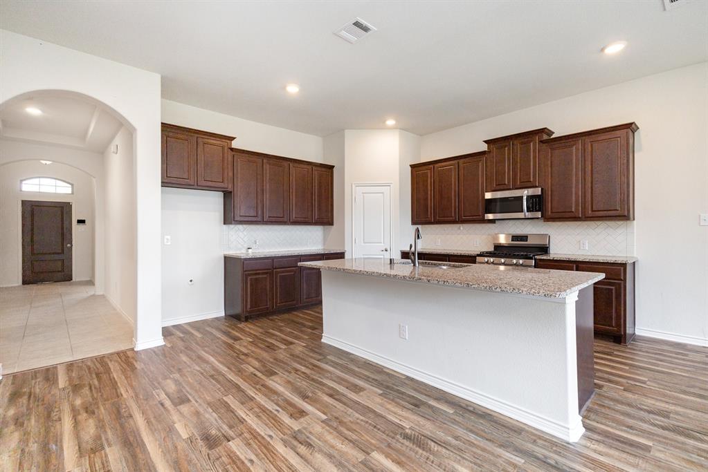 516 Maverick Street Anna, TX 75409 - Photo 7 of 28 a kitchen with stainless steel appliances a stove a sink a refrigerator white cabinets and a oven