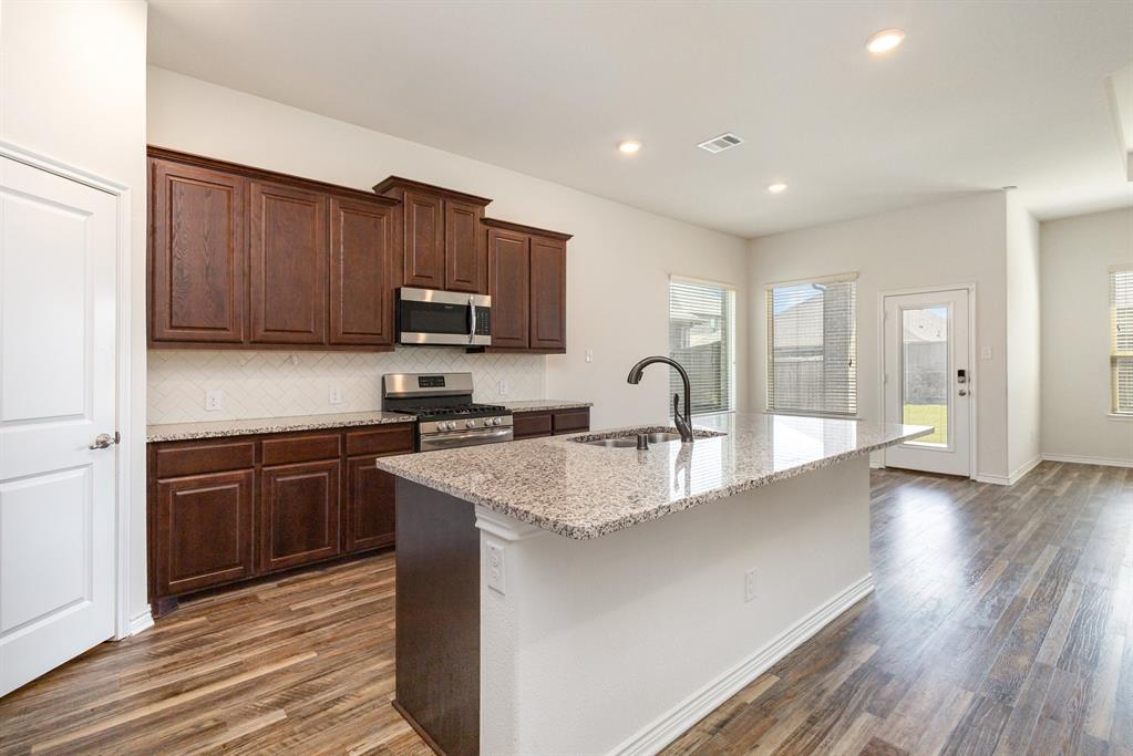 516 Maverick Street Anna, TX 75409 - Photo 8 of 28 a kitchen with stainless steel appliances granite countertop a sink stove and refrigerator
