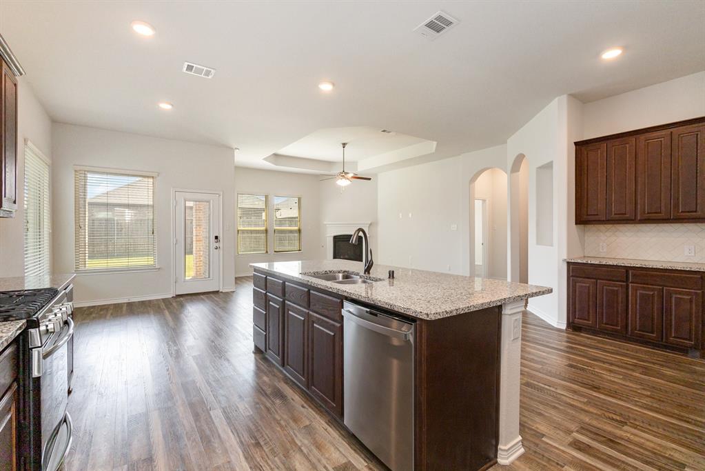 516 Maverick Street Anna, TX 75409 - Photo 9 of 28 a kitchen with stainless steel appliances granite countertop a sink stove and wooden floor