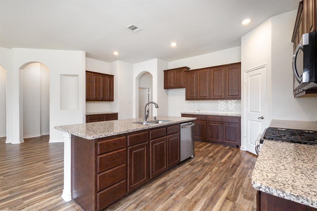 516 Maverick Street Anna, TX 75409 - Photo 10 of 28 a kitchen with stainless steel appliances granite countertop a sink stove and refrigerator