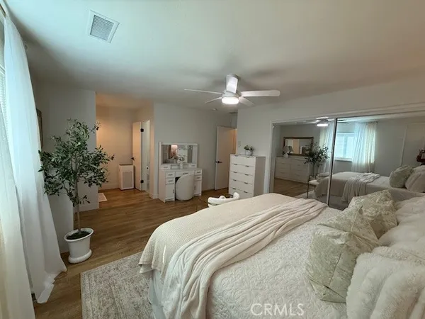 a spacious bedroom with a bed and chandelier