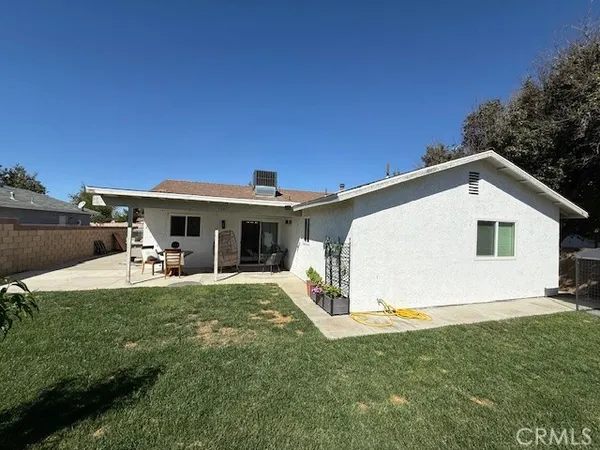 a view of a house with backyard and sitting area