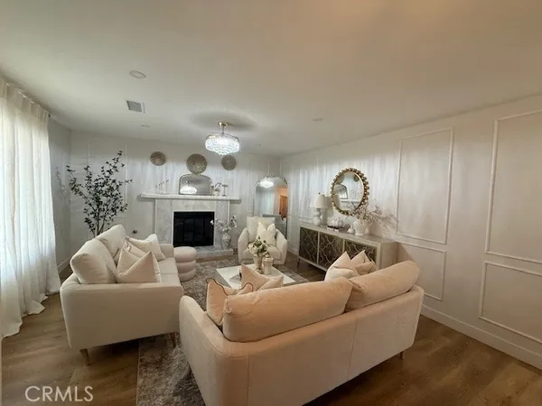 a living room with furniture a fireplace and a chandelier