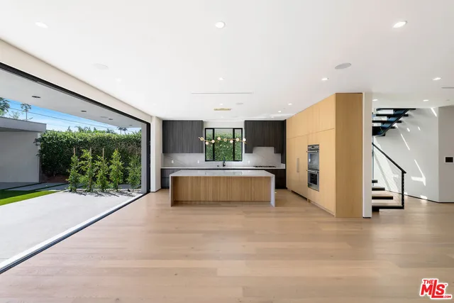 a kitchen with stainless steel appliances a large counter top and a refrigerator