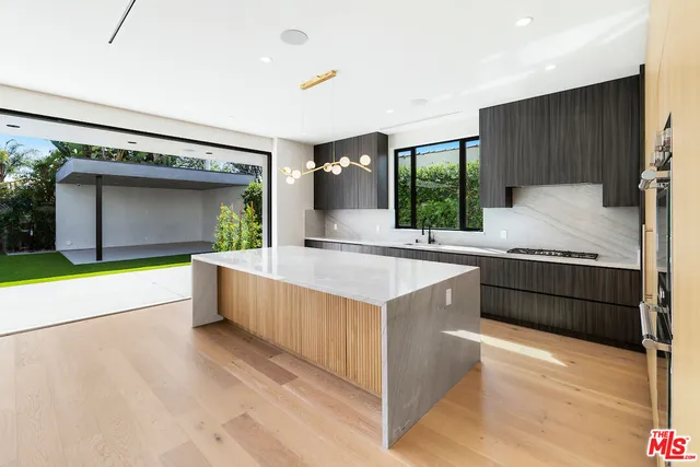 a kitchen with stainless steel appliances granite countertop a sink and a wooden floors