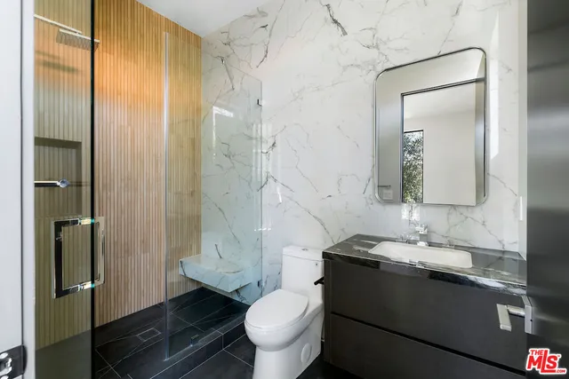 a bathroom with a granite countertop sink toilet and shower