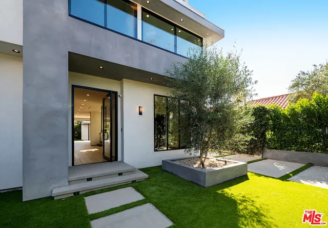 a view of a swimming pool with potted plants and big trees