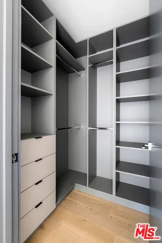 a view of walk in closet with empty racks