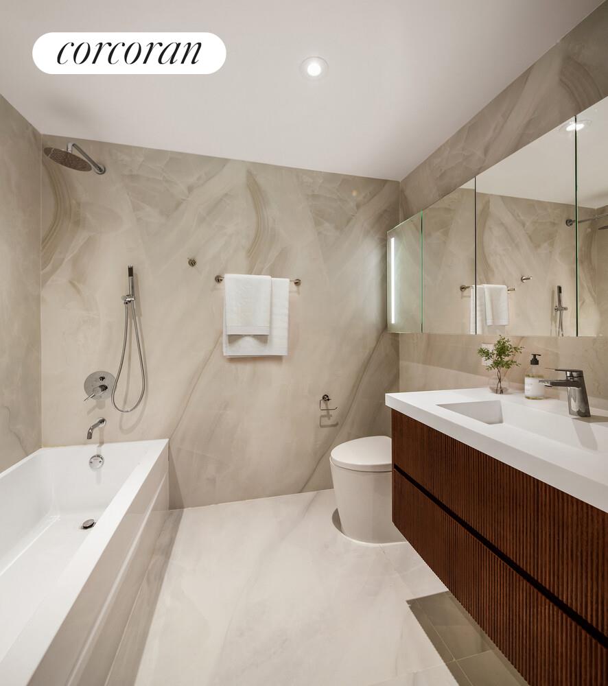 355 West 39th Street, Unit 9A Manhattan, NY 10018 - Photo 6 of 11 a spacious bathroom with a bathtub sink and toilet