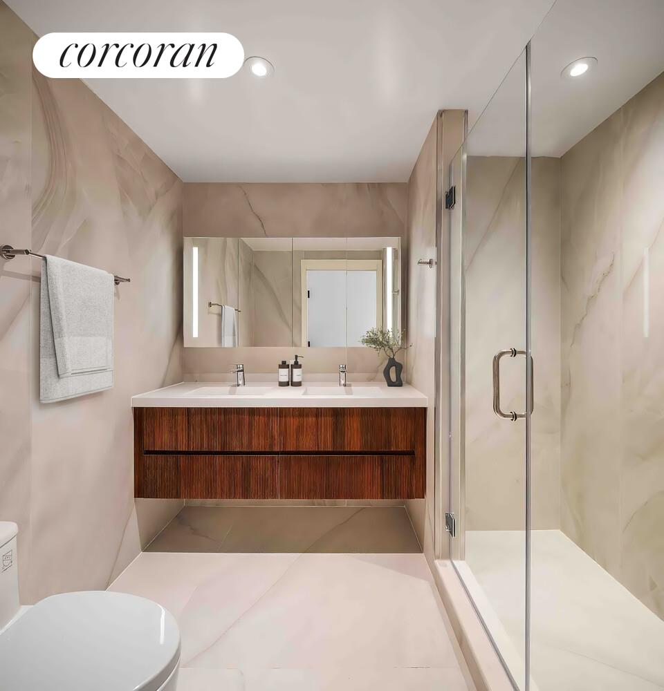 355 West 39th Street, Unit 9A Manhattan, NY 10018 - Photo 7 of 11 a bathroom with a sink a toilet and shower