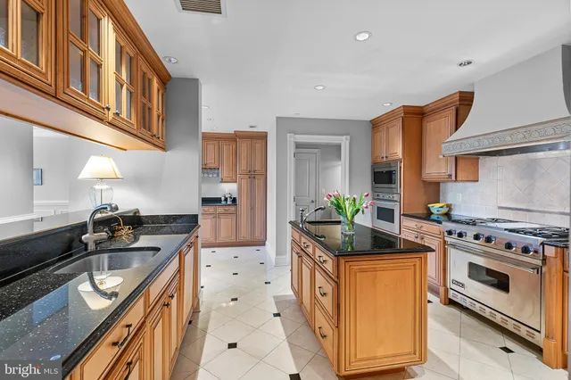 a kitchen with stainless steel appliances granite countertop a stove a sink and a refrigerator